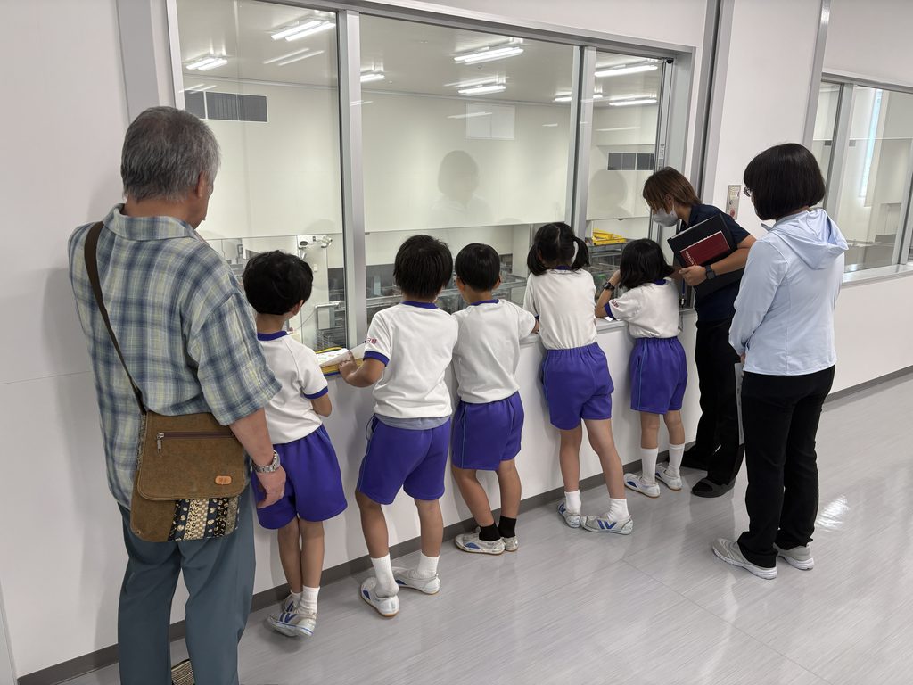 北日野小学校2年生の町探検で、ふじや食品の工場見学をする児童たち